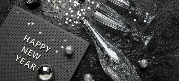 テキストとボードハッピー新年、眼鏡、シャンパンボトルと黒の背景にクリスマスの装飾 - 写真・画像