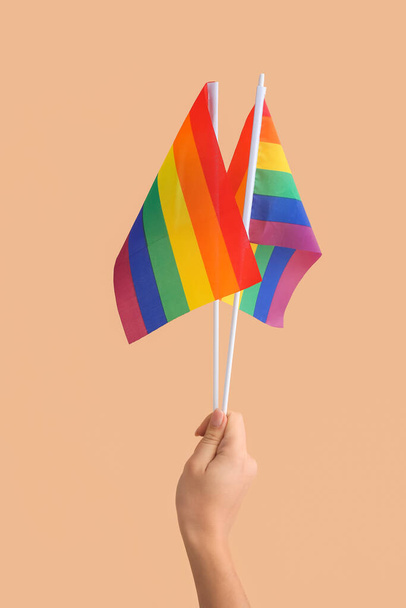 Female hand with LGBT flags on color background - Photo, Image