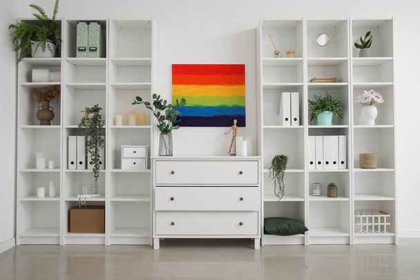 Interno della stanza luminosa con pittura arcobaleno, cassettiera e scaffali - Foto, immagini