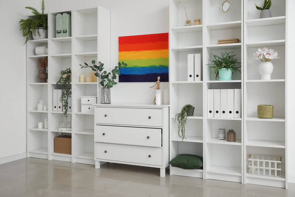 Interior da sala de luz com pintura arco-íris, peito e unidades de estantes - Foto, Imagem