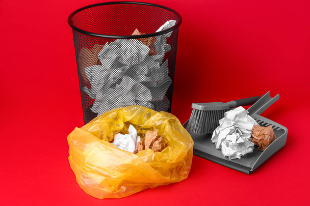 Ufficio bidone della spazzatura e borsa con carta spiegazzata su sfondo rosso - Foto, immagini