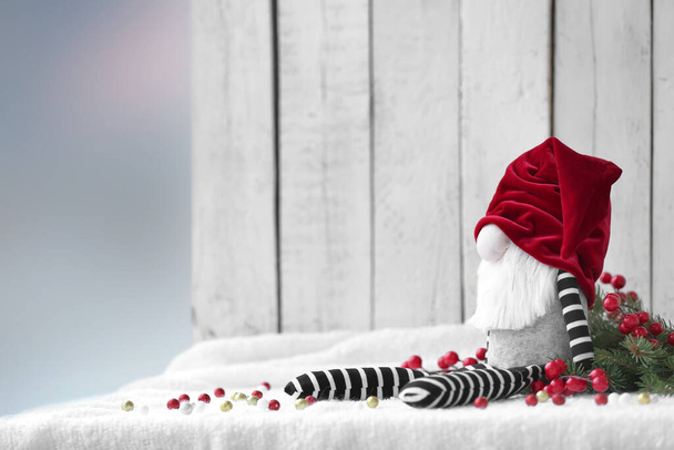Hauska joulu gnome lelu ja sisustus valkoinen kangas vastaan kevyt puinen tausta - Valokuva, kuva