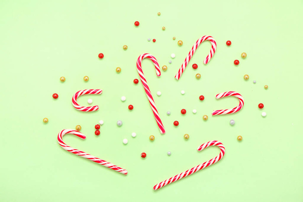 Composition with sweet candy canes and Christmas decor on color background - Photo, Image