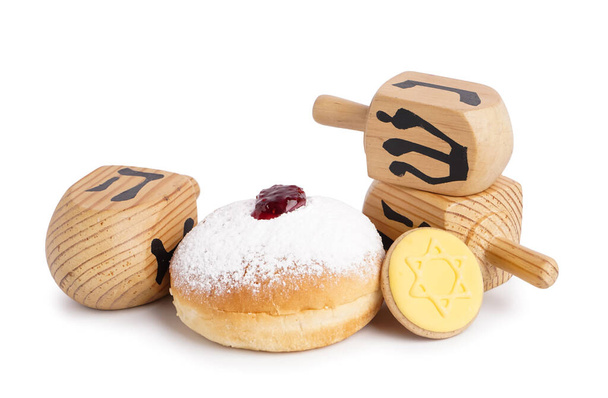 Beignet avec biscuit et dreidels pour la célébration de la Hannukah sur fond blanc - Photo, image