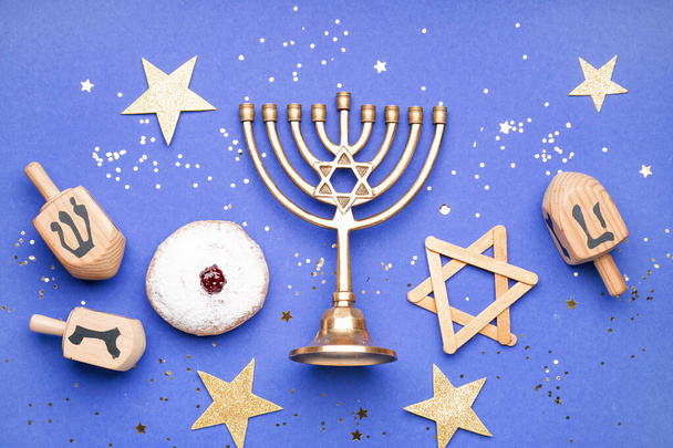 Menorah avec beignet, dreidels et étoiles pour la célébration de la Hannukah sur fond bleu - Photo, image