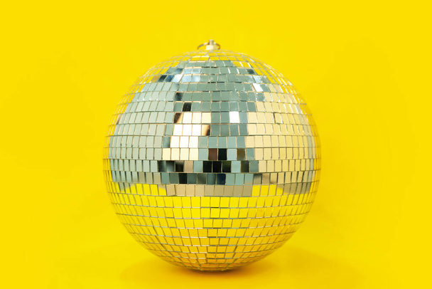 disco bal op gele achtergrond - Foto, afbeelding