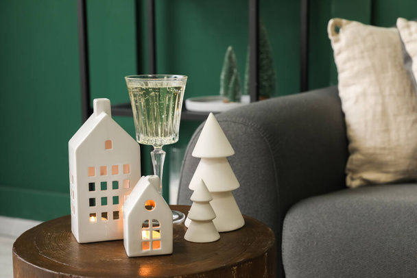 Castiçais em forma de casa e copo de champanhe na mesa na sala de estar - Foto, Imagem