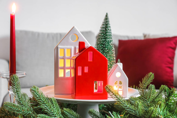 Підставка з тримачами для свічок у формі будинку та різдвяний вінок у вітальні
 - Фото, зображення