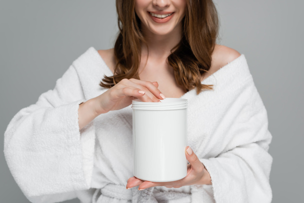 cropped view of woman with shiny hair holding container with treatment mask isolated on grey  - Foto, Imagem