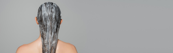 πίσω όψη της νεαρής γυναίκας με γυμνούς ώμους και μάσκα σε βρεγμένα μαλλιά απομονώνονται σε γκρι, πανό  - Φωτογραφία, εικόνα