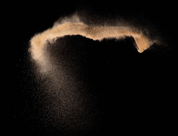 Esplosione volante di sabbia fine di piccole dimensioni, onda di grano dorato esplodere. Nuvole astratte volano. Sabbia gialla spruzzata di silice in Aria. Fondo nero Isolato otturatore ad alta velocità, lancio freeze shot - Foto, immagini