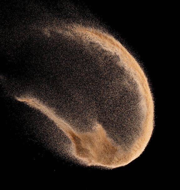 Μικρό μέγεθος λεπτής άμμου που πετά έκρηξη, χρυσό κύμα κόκκων εκραγεί. Αφηρημένη πτήση σύννεφο. Κίτρινο χρώμα άμμο βουτιά πυριτία στον αέρα. Μαύρο φόντο Απομονωμένο κλείστρο υψηλής ταχύτητας, ρίψη παγώματος shot - Φωτογραφία, εικόνα