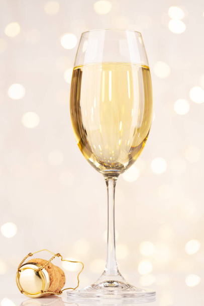 Бокал шампанского перед рождественскими огнями боке - Фото, изображение