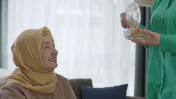 Muslimská tradice v ramadánu.Hidžáb oblečená žena nabízí cukroví své matce na oslavu Eid al-Fitr tradičně po konci svatého měsíce. - Záběry, video