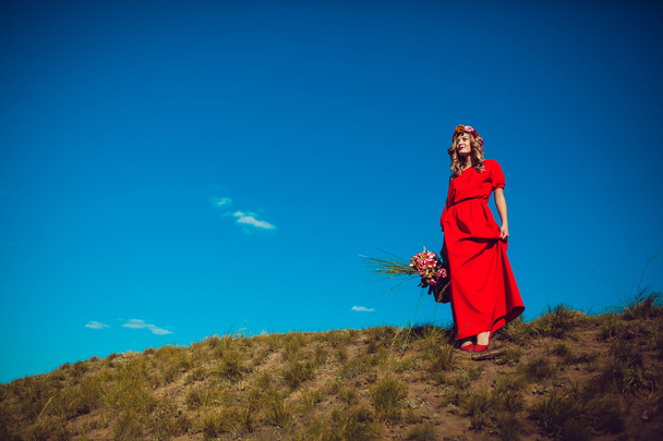 Dívka v červených šatech je chůze na hřišti - Fotografie, Obrázek