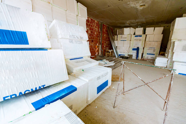 Verpackungen aus Wärmedämmmaterial, Styropor, in Folie gewickelt, die darauf wartet, an den Wänden installiert zu werden, im Lager platziert. - Foto, Bild