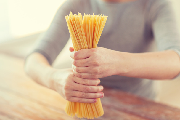close up of female hands holding spaghetti pasta - Foto, afbeelding