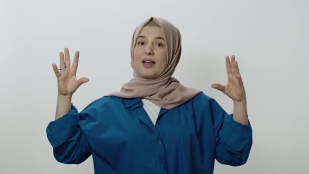 Hidžáb žena je velmi naštvaný na to, co se stalo. Indoor studio záběr izolované na bílém pozadí. Žena si dělá legraci z jednání tím, že dělá gesta, nebo tak něco. - Záběry, video