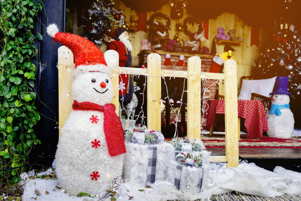 Güzel dekoratif yapay kardan adam dekorasyonu küçük bir yerleşim yerinin girişinde. Noel tatilinde halk parkının önünde duran kardan adam. Noel ve Yeni Yıl Konsepti. - Fotoğraf, Görsel