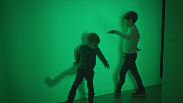 μοντέρνα αρσενικά παιδιά παίζουν με το φως αφήνοντας εντυπώσεις σκιά με τη βοήθεια της επιστήμης και της φυσικής σε ένα διαδραστικό δωμάτιο - Πλάνα, βίντεο