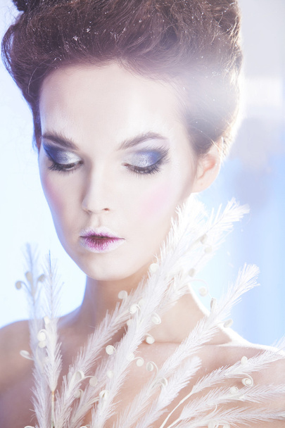 Beauty woman over blue winter background. Winter beauty woman. Snow queen. Make-up - 写真・画像