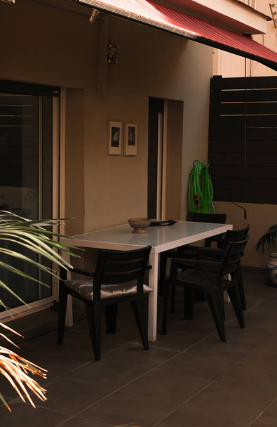 відкрита тераса в квартирі з обіднім столом і стільцями
 - Фото, зображення