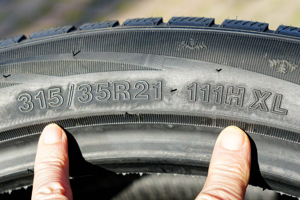 Seitenansicht des neuen Reifens mit Reifenbreite, Höhe und Raddurchmesser Bezeichnungen und Geschwindigkeits- und Lastindizes, Reifenmarkierung, Geschwindigkeits- und Lastmarkierung - Foto, Bild