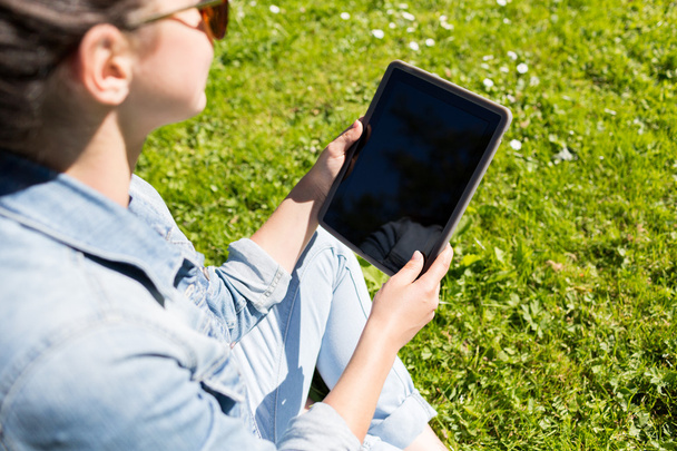 close up of girl with tablet pc sitting on grass - Valokuva, kuva