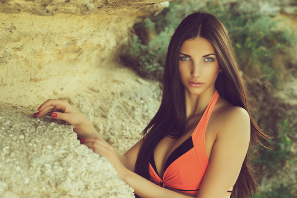 Girl in  swimsuit on the rocks - Foto, Imagen