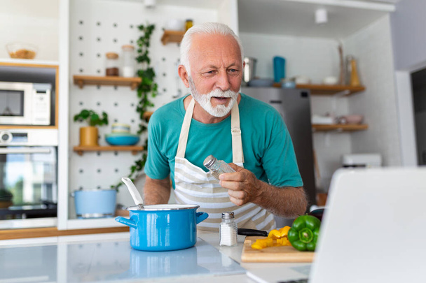Iloinen vanhempi mies hauskaa ruoanlaitto kotona - Vanhukset valmistelevat terveys lounas moderni keittiö - Eläkkeellä elämäntapa aikaa ja elintarvikkeiden ravitsemus käsite - Valokuva, kuva