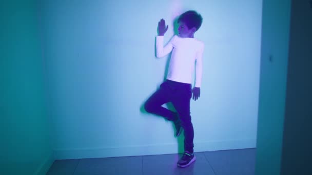 rozrywka i edukacja, wesoły chłopiec bawi się światłem pozostawia cienie na ścianie z pomocą fizyki w interaktywnym pomieszczeniu - Materiał filmowy, wideo