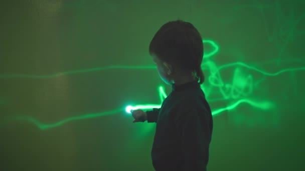 ładny mały chłopiec rysunek z latarką na zielonej ścianie pozostawiając wzory, nauka i nauka - Materiał filmowy, wideo