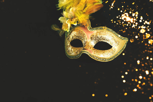 Máscara de carnaval dourado no fundo escuro com brilhos. Conceito de Mardi Gras ou decoração de Ano Novo. Conceito fundo festivo ou design.  - Foto, Imagem