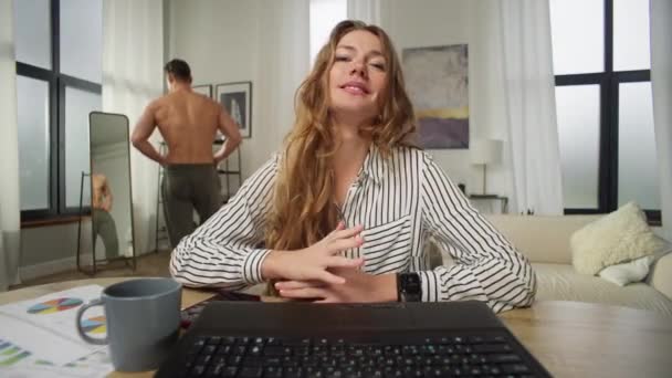 A businesswoman communicates about work on zoom, and her boyfriend walks naked into the frame. A man prevents a businessman from working from home. Girls home office. Funny video  - Footage, Video