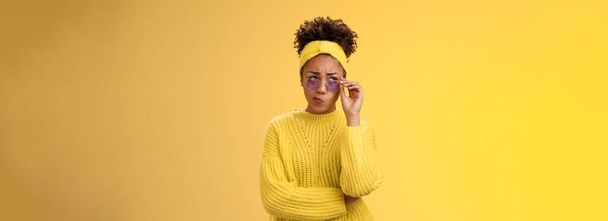Perpleja insegura elegante africana-americana diseñadora creativa en diadema suéter gafas de sol sonriendo labios plegables tubo incierto tienen dudas fruncir el ceño mirar hacia arriba reflexivo no puede decidir. - Foto, Imagen