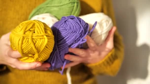 Espetos de fios de cores diferentes em mãos.Hobby e conceito de bordado. Fios de lã em amarelo, bege, roxo e verde. Tricotar roupas quentes com suas próprias mãos. Imagens 4k de alta qualidade - Filmagem, Vídeo