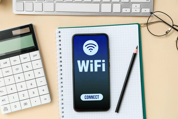 Tastatur, Brille, Schreibwaren und Handy mit WiFi-Symbol auf farbigem Hintergrund - Foto, Bild