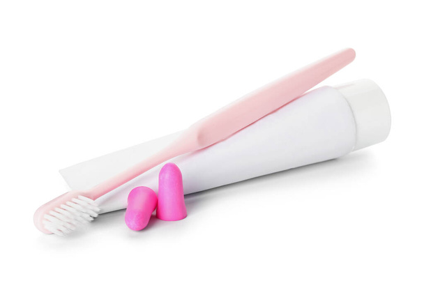 Ear plugs, toothbrush and paste on white background - Photo, Image