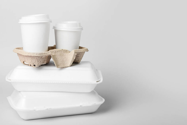 Montón de cajas de comida y soporte con vasos de papel sobre fondo claro - Foto, imagen
