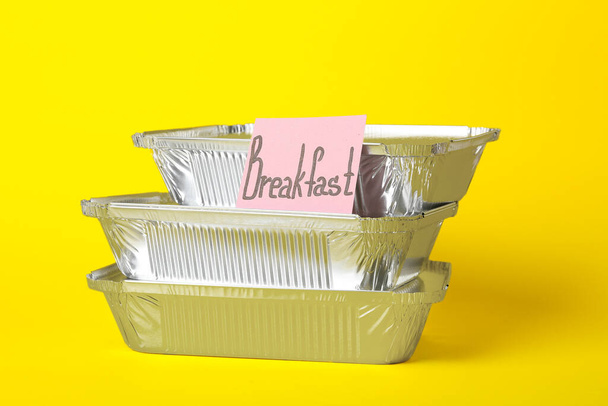 Пачка коробок для еды на вынос и липкая записка со словом BREAKFAST на цветном фоне - Фото, изображение