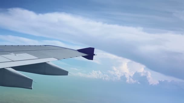 Vleugel van een vliegtuig vliegen boven de wolken, geschoten vanuit het raam van het vliegtuig - Video