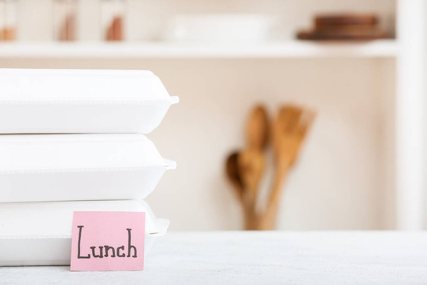 Еда контейнеры и липкая записка со словом Обед на белом столе - Фото, изображение