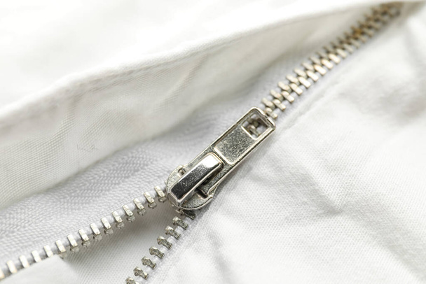 Closeup view of metal zipper on white clothes - Photo, Image