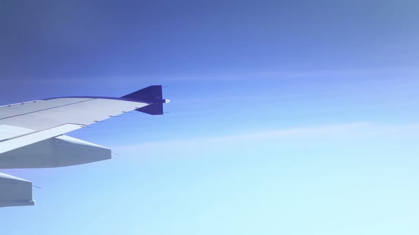 Vleugel van een vliegtuig vliegen boven de wolken, geschoten vanuit het raam van het vliegtuig - Video
