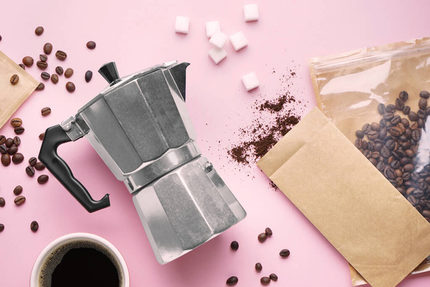 Geysir-Kaffeemaschine, Tasse Espresso, Zucker und Beutel mit Bohnen auf rosa Hintergrund - Foto, Bild