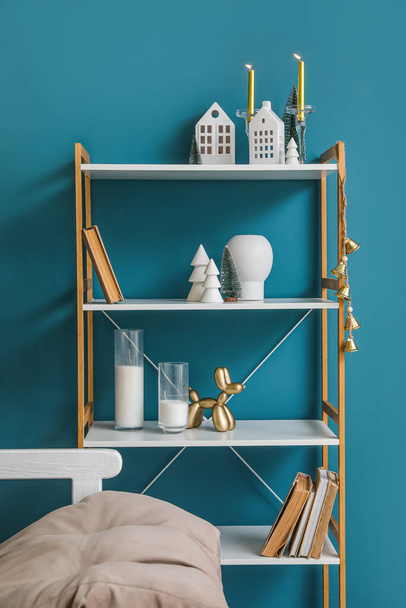 Shelving unit with candle holders and Christmas trees near blue wall - Photo, Image