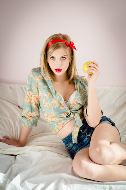 Rockabilly girl with apple in bed - Photo, Image