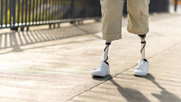 View of a walking man with prosthetic legs and white sneakers - Photo, Image