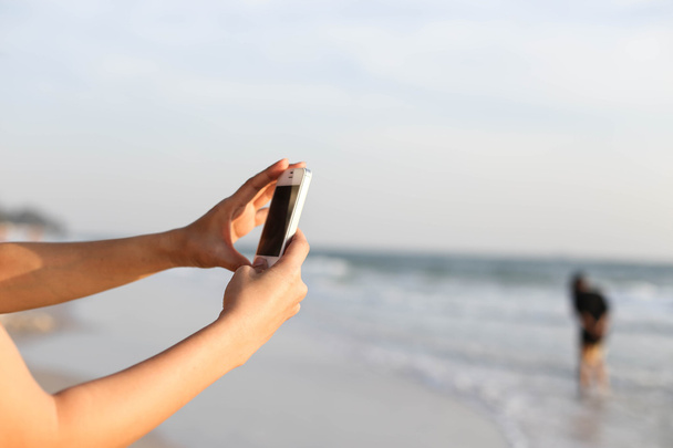 Жінки з фотографуванням пляжу з смартфоном
 - Фото, зображення
