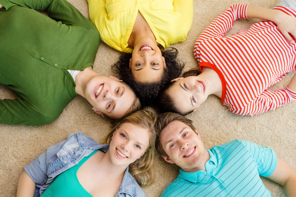 Gruppe lächelnder Menschen legt sich auf den Boden - Foto, Bild